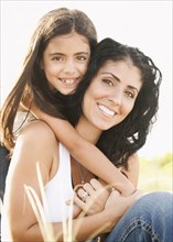 Portrait of Mixed Race girl hugging mother outdoors