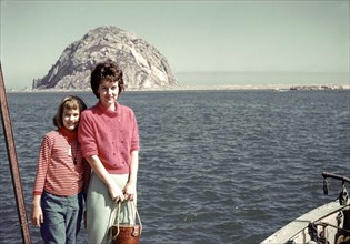 Caucasian mother and daughter posing near ocean