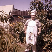 Caucasian man standing in yard wearing chef hat and apron