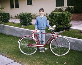 Portrait of smiling Caucasian boy posing with bicycle