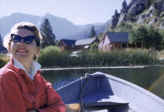 Caucasian woman sitting in boat on lake
