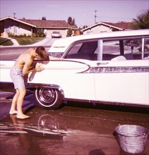 Caucasian boy washing car