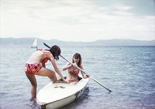 Caucasian girls in kayak on lake