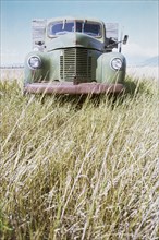 Abandoned truck in field of grass