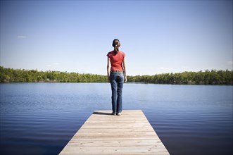 Mixed Race woman at the edge of dock at lake
