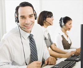Customer service representatives wearing headsets using computers