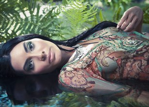 Exotic Hispanic woman laying in water