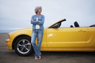 Caucasian woman leaning on convertible
