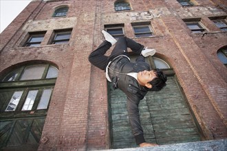 Man breakdancing in urban area