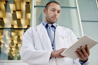 Doctor using digital tablet outdoors