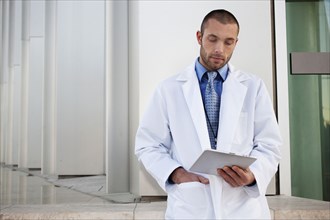Doctor using digital tablet outdoors