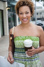 African American woman shopping and drinking coffee