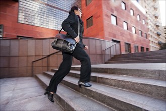 Businesswoman running up steps