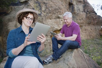 Caucasian couple using digital tablet in remote area