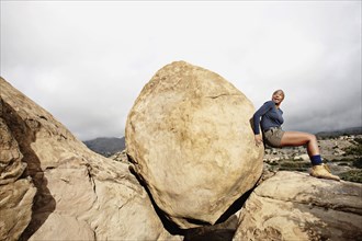 Black woman pushing large rock
