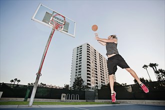 Caucasian man playing basketball outdoors