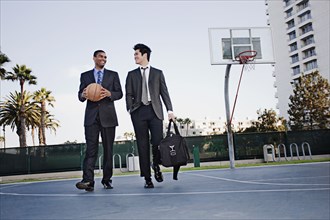 Businessmen walking on basketball court