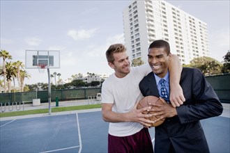 Businessman with friend on basketball court