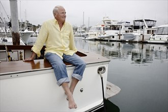 Smiling man sitting on boat in marina