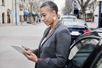 Black businesswoman using digital tablet outdoors