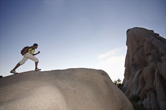 Woman hiking on large rock