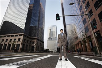 Businessman standing in urban crosswalk