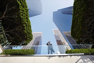 Businessman standing on balcony talking on cell phone