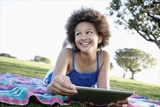Girl using digital tablet in park
