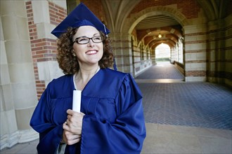Smiling Caucasian woman holding graduation diploma