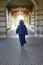 Caucasian graduate walking in portico