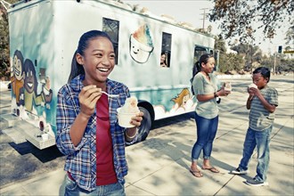 Girl eating ice cream from truck