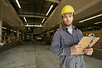 Caucasian worker with clipboard in warehouse