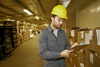 Caucasian worker checking product in warehouse