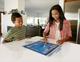 Children playing on computer in table