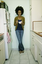Mixed race woman eating cereal in kitchen