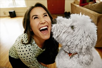 Dog licking Caucasian woman's face