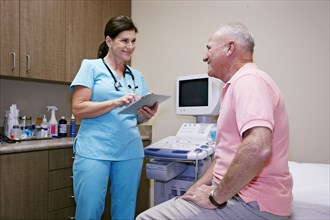 Caucasian nurse talking to patient in office