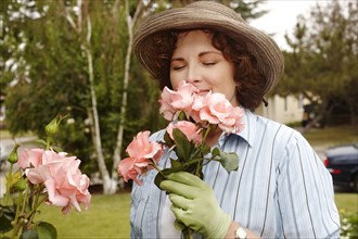 Woman smelling roses in garden
