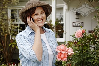 Smiling woman talking on cell phone in garden