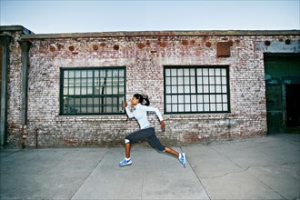 Black woman running on city street