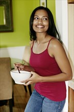 Indian woman having bowl of cereal
