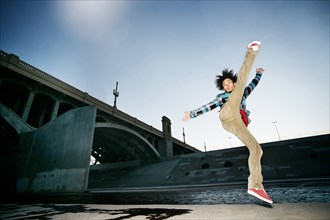 Asian man break dancing under overpass