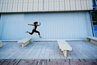 Mixed race woman running on city street