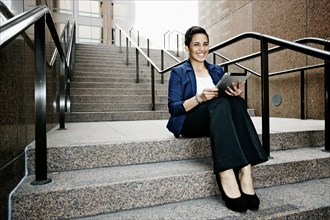Hispanic businesswoman using tablet computer