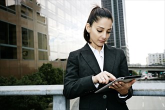 Mixed race businesswoman using tablet computer