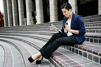 Hispanic businesswoman using tablet computer
