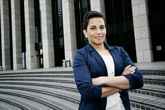 Hispanic businesswoman standing on steps