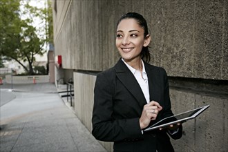 Mixed race businesswoman using tablet computer