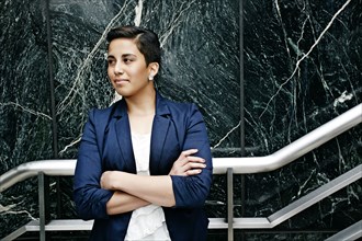 Hispanic businesswoman standing on steps