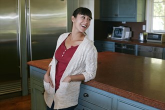 Mixed race woman smiling in kitchen